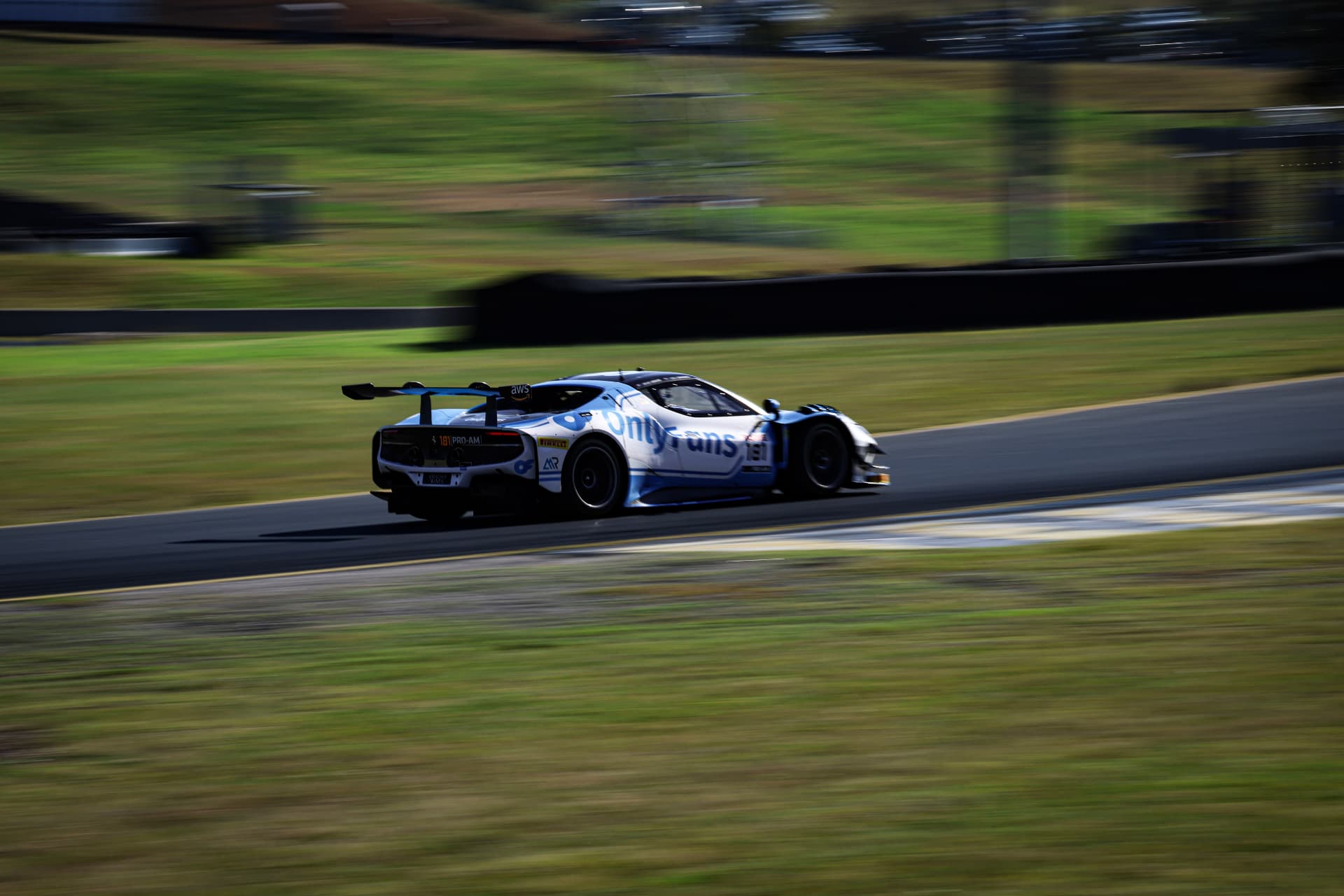 White GT car panned through a fast bend