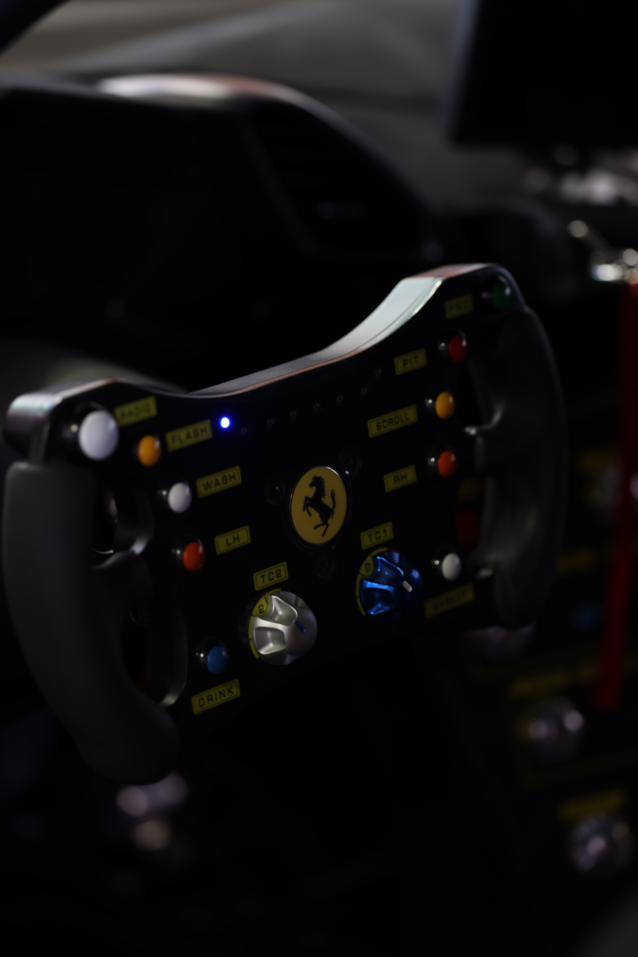 Ferrari racing steering wheel glowing in low light