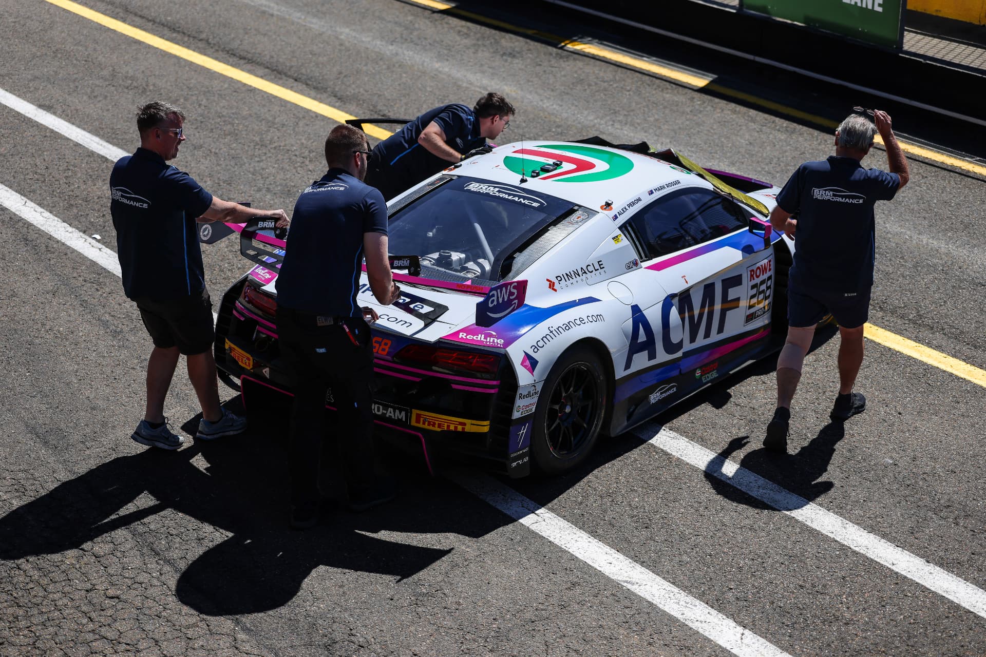 Audi R8 GT car being pushed along pit lane by its crew