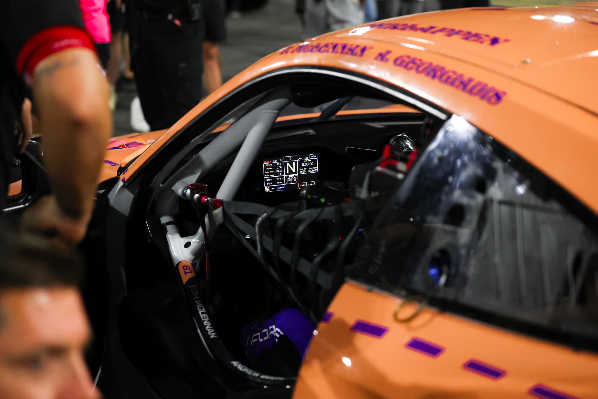 Orange race car cockpit and illuminated dashboard in the garage