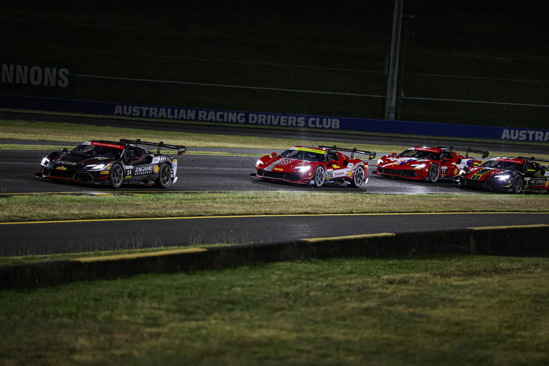 Four GT cars running together under lights