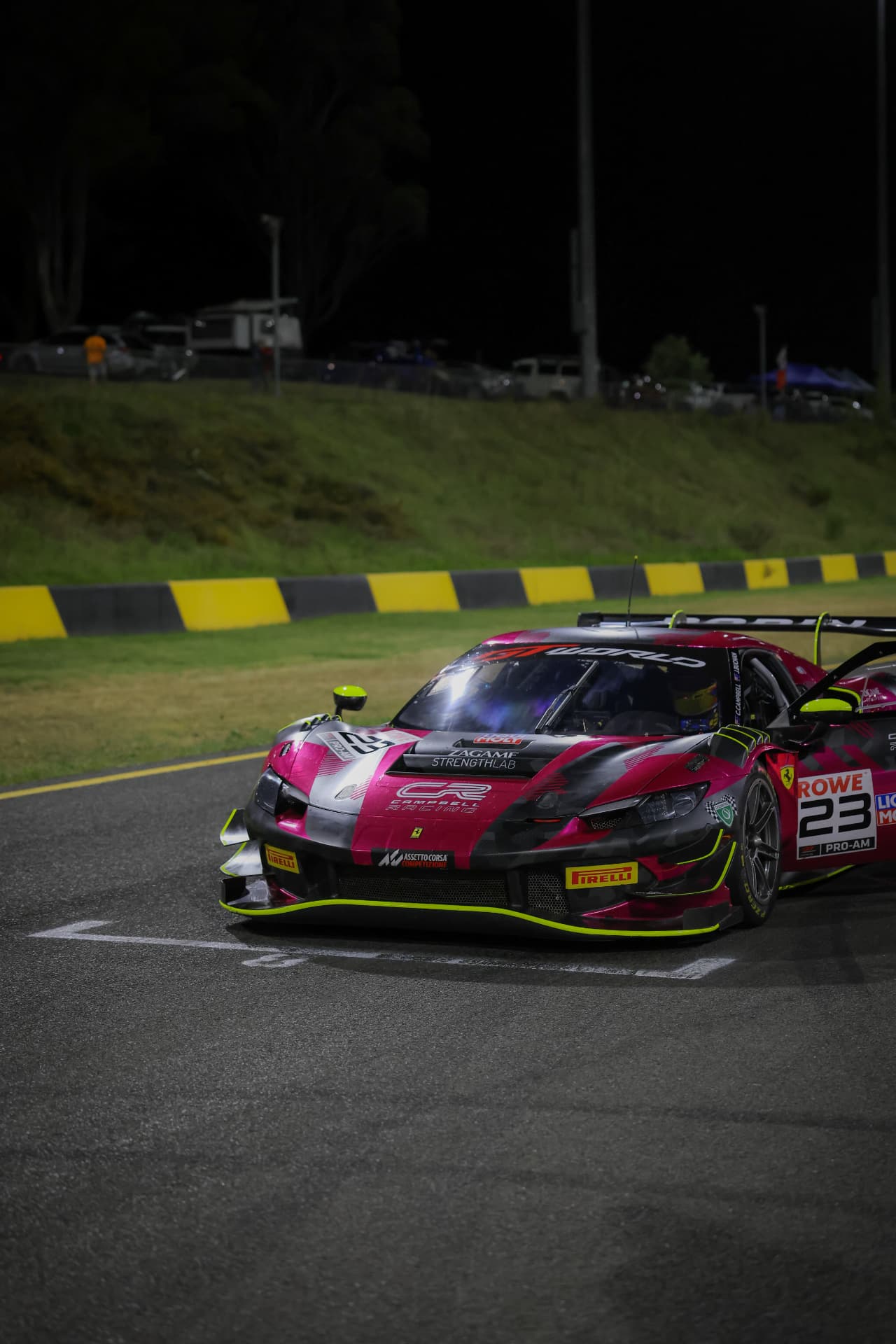 Pink and black Ferrari GT car on the night circuit