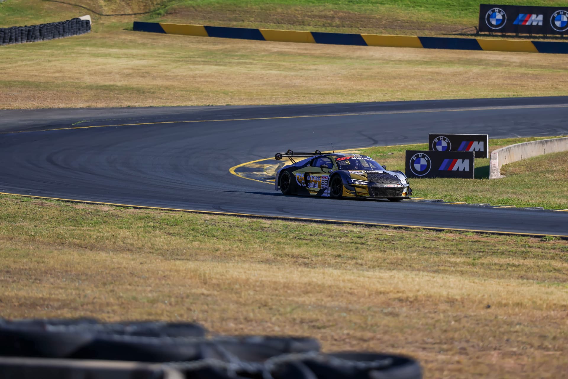 Black and gold Audi R8 GT car clipping the corner kerb