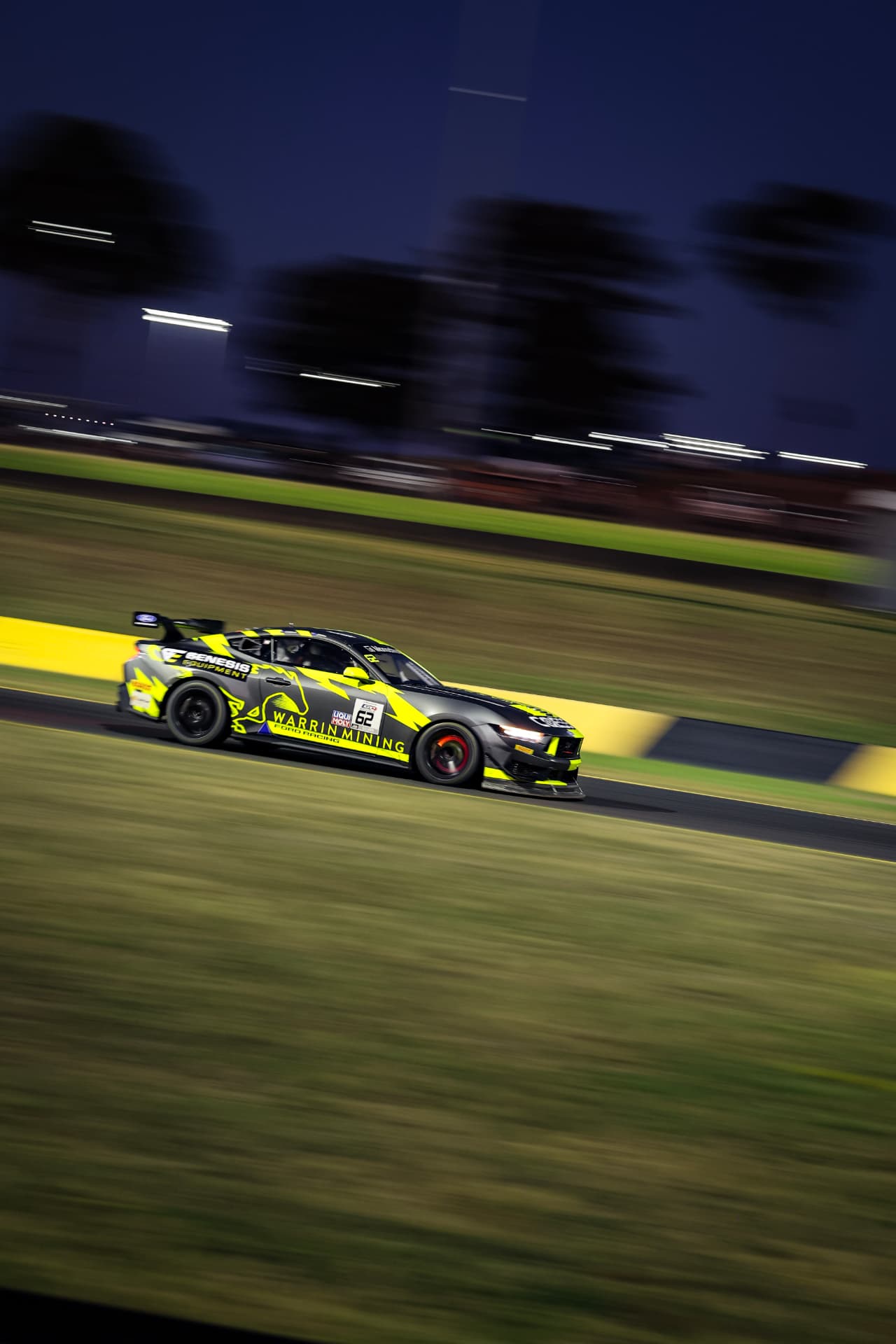 Yellow and black Mustang #62 panned at speed at night