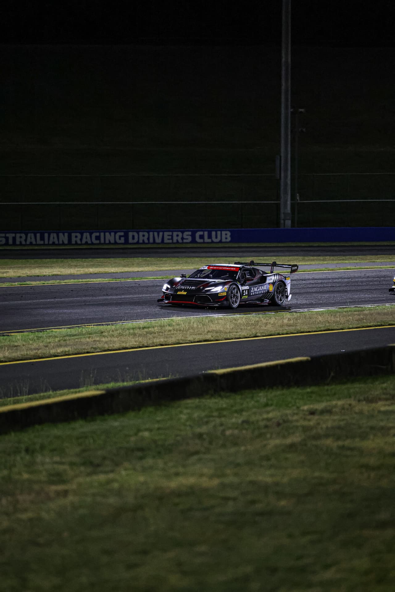 Black Zagame Ferrari #14 on track at night