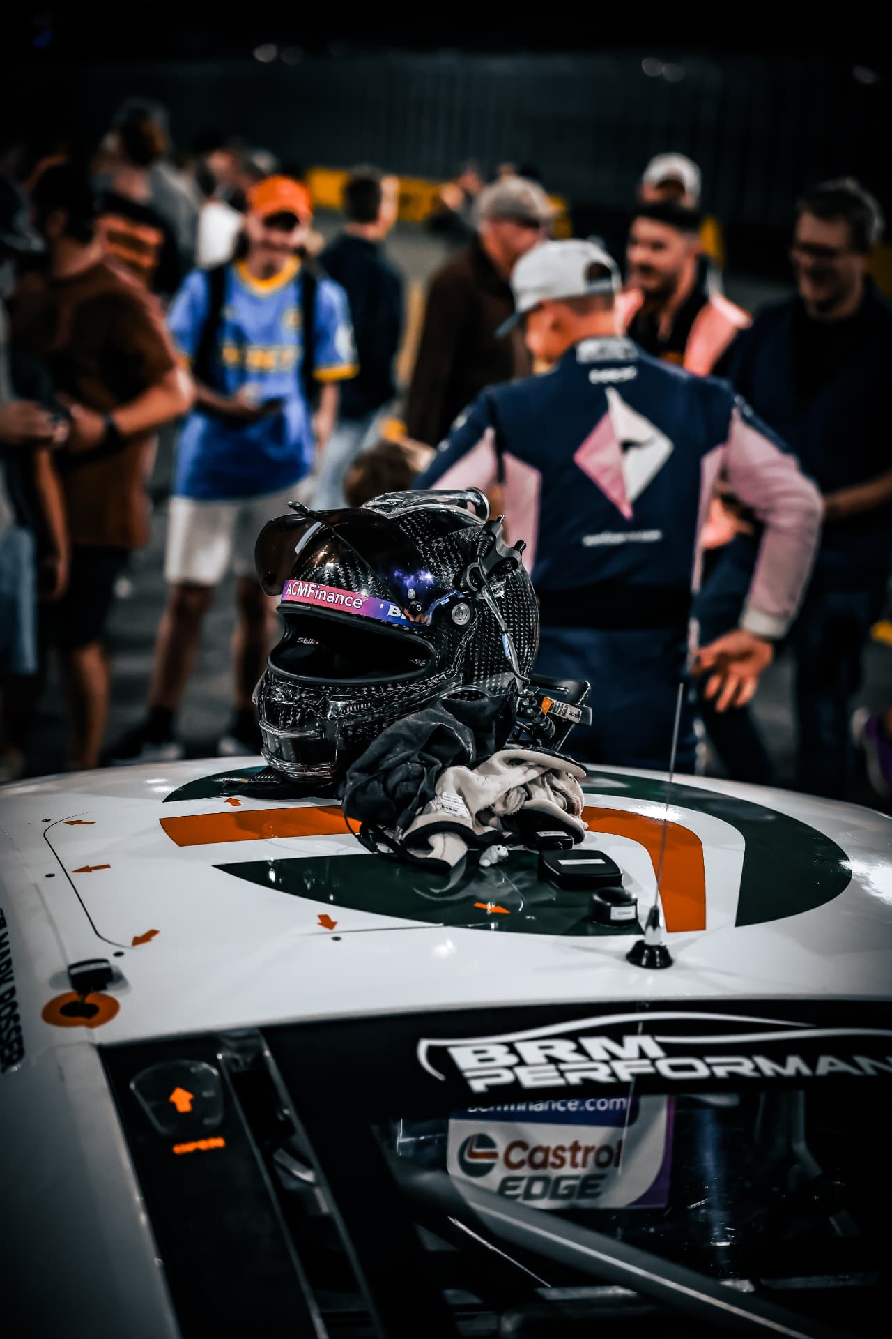 Driver's helmet and gloves resting on a race car after a session